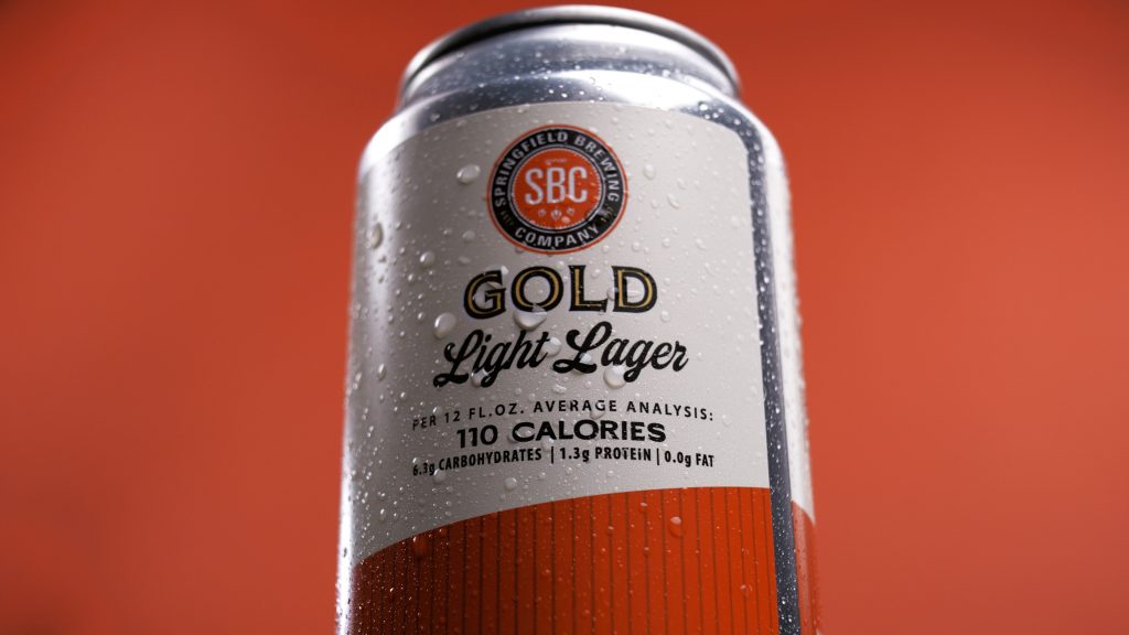 Close-up beauty shot of a Gold Light Lager can with condensation for a tabletop advertising campaign case study.